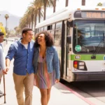 Two friends laughing and chatting while walking toward a parked RTA bus on a sunny day in Riverside, California.