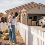 Neighbors chatting over a fence in an Apache Junction yard with cactus landscaping and a nearby home