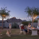 Friends and neighbors gather in a backyard in Apache Junction, AZ at dusk
