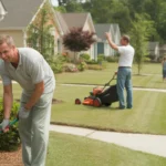 Homeowner trimming shrubs in front of suburban house while neighbor mows lawn across street in Rock Hill, SC neighborhood