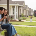 Couple sitting on front porch swing of their home in League City, Texas
