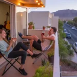 Two roommates hanging out on their apartment balcony in Paradise, NV at sunset