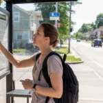 A young woman checks the bus schedule at a neighborhood transit shelter in Elgin, IL