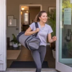 Young woman carrying gym bag enters apartment building in Rock Hill, SC